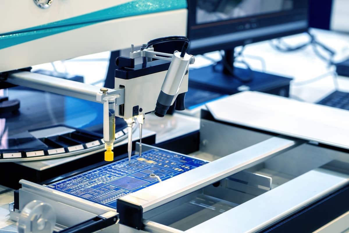 Close-up of an automated system handling a circuit board.